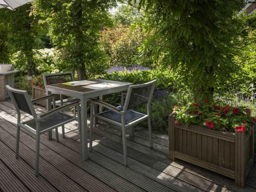 a table and chairs on a deck with flowers at ibis Rotterdam Vlaardingen in Vlaardingen