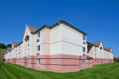 a large pink and white building on a grass field at Sonesta Simply Suites Pittsburgh Airport in Imperial