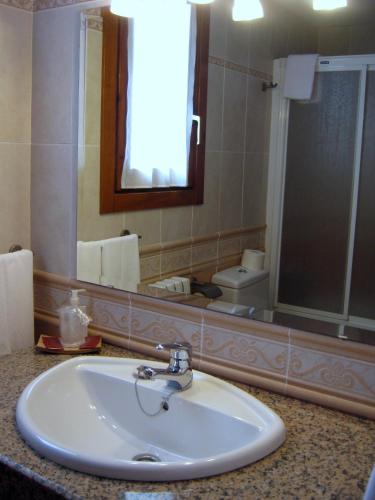 a bathroom with a sink and a mirror at Casa La Abadía in Cerler
