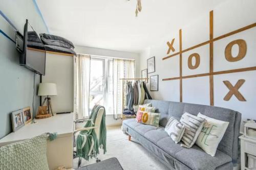 a living room with a gray couch and a window at 2-Bedroom Flat in Woking Walk to Station in Hurley