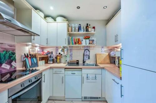a kitchen with white cabinets and white appliances at 2-Bedroom Flat in Woking Walk to Station in Hurley