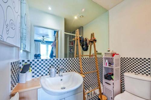 a bathroom with a sink and a toilet and a mirror at 2-Bedroom Flat in Woking Walk to Station in Hurley