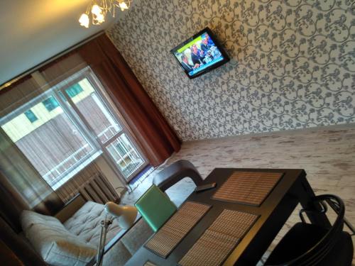 カリーニングラードにあるApartments on Teatralnaya 33のリビングルーム(テーブル、壁掛けテレビ付)
