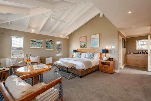 ein Schlafzimmer mit einem großen Bett und einem Tisch in der Unterkunft Camps Bay Retreat Hotel in Kapstadt