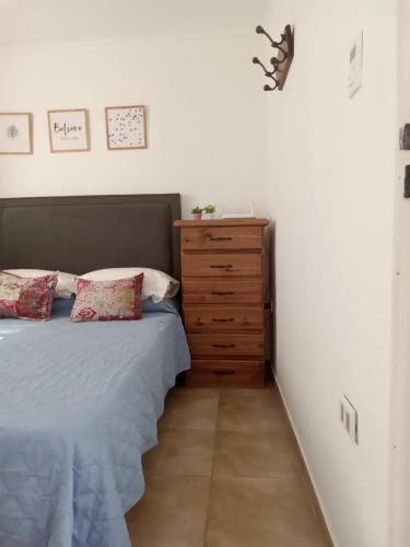 科连特斯WyW PEATONAL JUNIN的带床和木制梳妆台的卧室