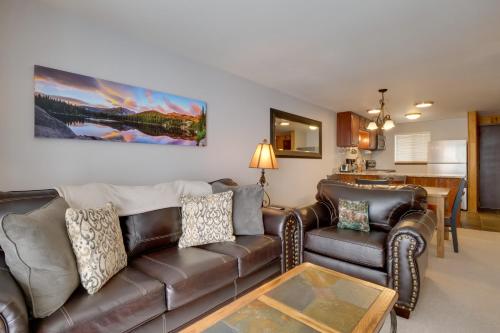a living room with a leather couch and a table at Winter Park Condo with Hot Tubs, 4 Mi to Ski Resort! in Winter Park