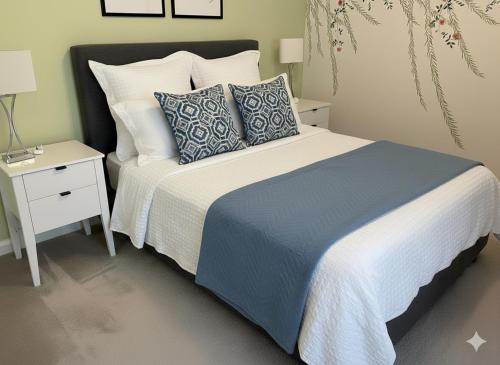 a bedroom with a bed with blue and white pillows at Cozy Flat for 2 River of Thames with FREE Parking in Staines