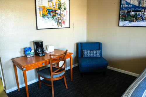 a desk and a blue chair in a room at Yellowstone Motel in Idaho Falls