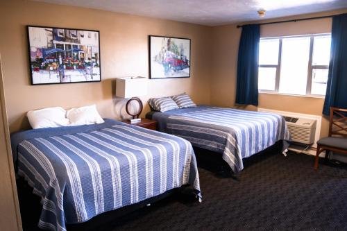 a hotel room with two beds and a window at Yellowstone Motel in Idaho Falls