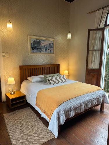a bedroom with a large bed and a window at Casa Verde Petrópolis in Petrópolis