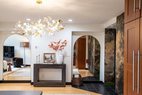 a living room with a fireplace and a chandelier at Forest Green Retreat in Brattleboro