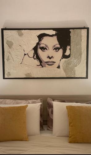 a painting of a woman on a wall above a bed at B&B Le due sorelle in Telese