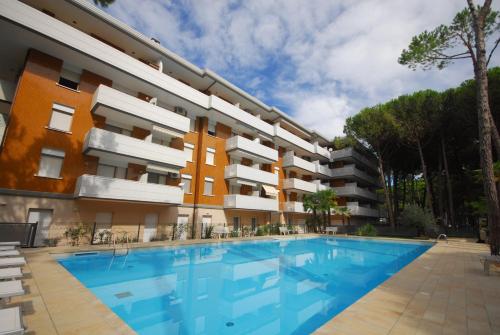 un edificio de apartamentos con una gran piscina en Residence Schubert, en Lignano Sabbiadoro