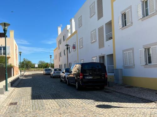una strada con auto parcheggiate accanto a un edificio di APF Beach T2 Cabanas Home by Junto ao Mar a Cabanas de Tavira