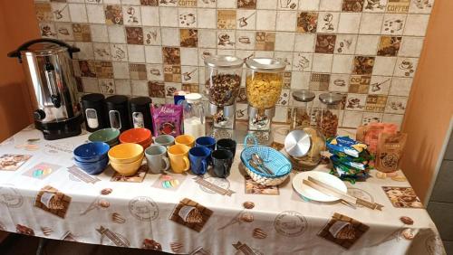 a table with a table cloth with cups and dishes on it at Jopi Hostel Katowice Centrum in Katowice