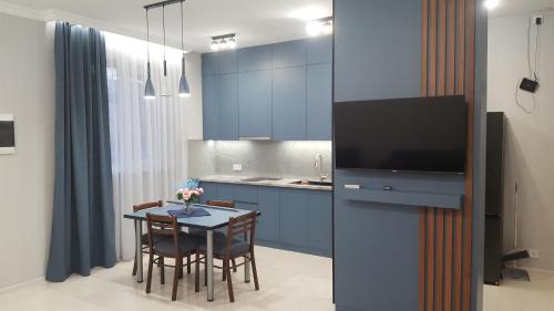 una cucina con un tavolo con sedie e una tv di Уют 2 a Yerevan