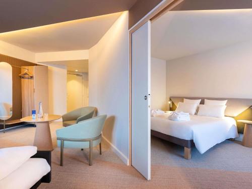 ランジスにあるNovotel Paris Orly Rungis Aéroportのベッドとテーブルのあるホテルの部屋
