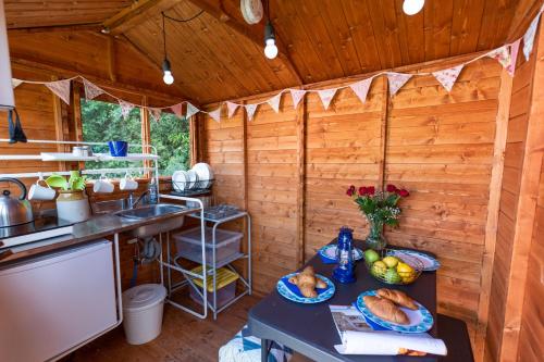 a kitchen with a table with food on it at Leafy Fields Glamping in Ashill