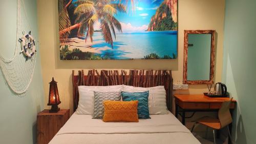 Un dormitorio con una cama con un cuadro en la pared. en Bayside & Beach Inn Langkawi, en Langkaw Island