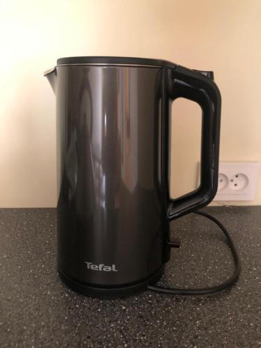 a black coffee pot sitting on top of a counter at Green House Apartment in Kaunas