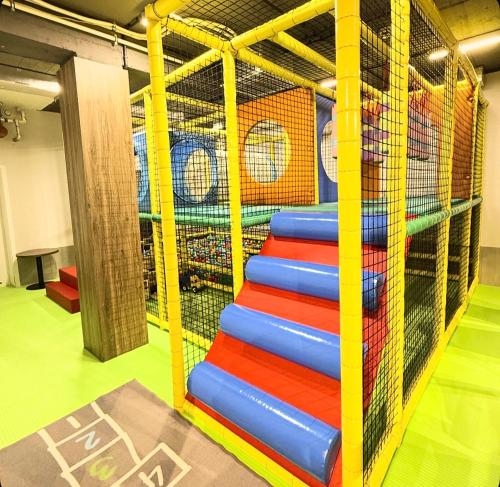 GÓRALSKIE NOWE APARTAMENTY BIAŁKA - Skibus, Sauny, Bania, Sale zabaw - w cenie في بيالكا تاترزانسكا: مجموعة من الشرائح الملونة في غرفة اللعب