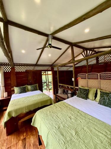a bedroom with two beds and a ceiling at Casa Oropéndola Refugio natural en Guanacaste in Bagaces