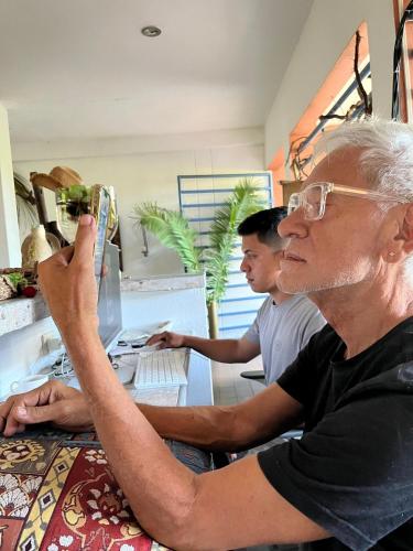 an older man sitting at a table using a computer at Hotel Selva HQ in Palomino