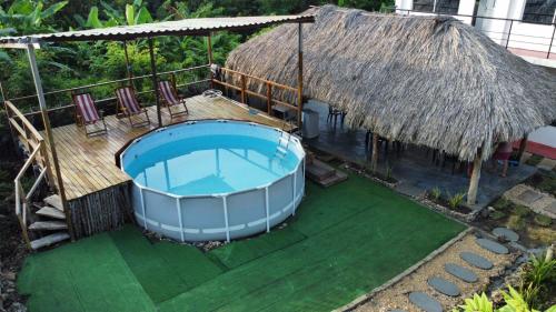 a house with a large swimming pool and a thatch roof at Hotel Paradise in Isla Fuerte