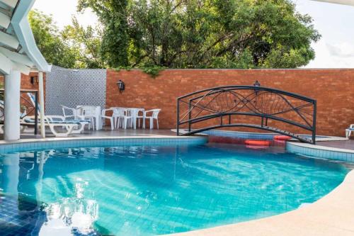 a swimming pool with a metal bridge over the water at Hotel Paraíso das Águas Bonito in Bonito