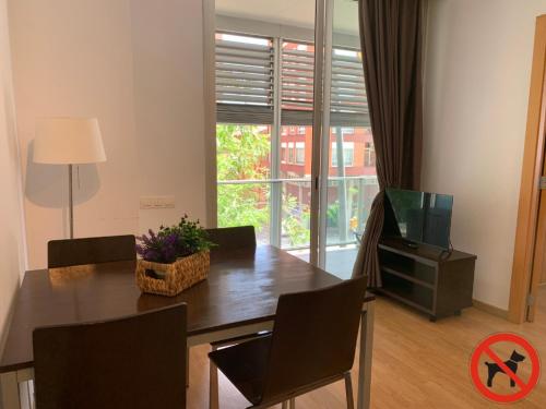 Un comedor con una mesa y un televisor. en Hotel Travessera, en Barcelona