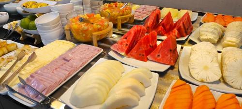 a buffet with many different types of food on plates at Abudi Hotel in Cuiabá