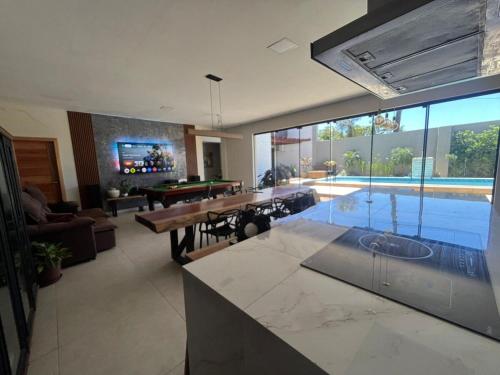 uma sala de estar com uma mesa de bilhar e uma sala de jantar em Linda casa com piscina - locação temporada em itapoá sc em Itapoa