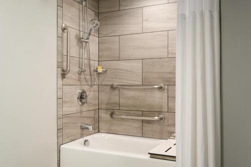 a bathroom with a tub and a shower at DoubleTree by Hilton St. Paul, MN in Saint Paul