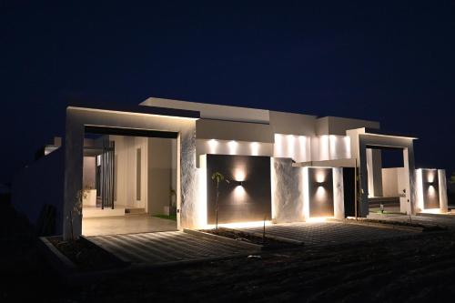 una casa iluminada por la noche con luces en Nasma chalets, en Barka