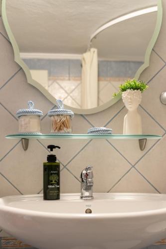 a bathroom sink with a mirror and a soap dispenser on it at aEN Fine Living in Edessa