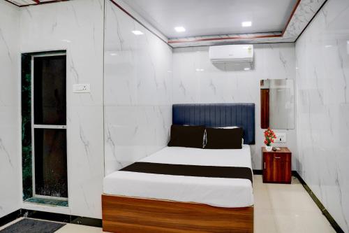a bedroom with a bed and a window at Hotel O SR Residency in Mumbai
