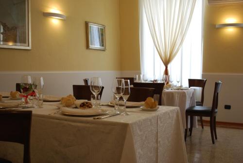 a dining room with tables with white tablecloths and glasses at Il Convento in Trino