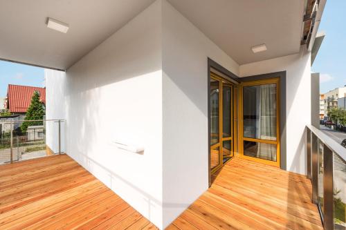 a room with a white wall and wooden flooring at Baltic Sands in Hel
