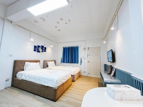 two beds in a room with a tv and a couch at Amphawa Horse Farm Resort in Ban Bang Khan Taek (1)