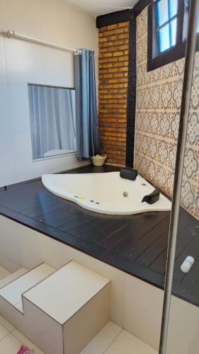 a bathroom with a white tub in a room at Pousada Nautillus in Arraial do Cabo