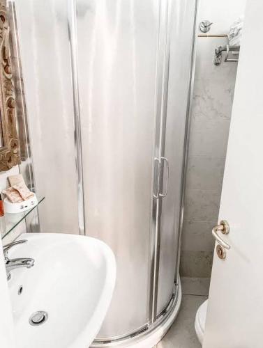 a white bathroom with a shower and a sink at Coelho Boutique Hotel in Gatteo a Mare