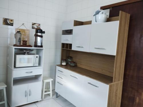 a kitchen with a white refrigerator and a microwave at Casa paulo e nubia in Imbé