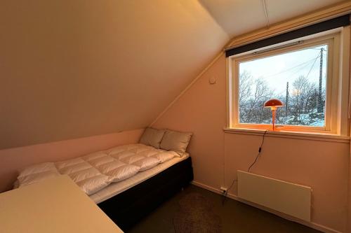 een kleine slaapkamer met een bed en een raam bij Coastal Comfort Ure in Vestvågøya
