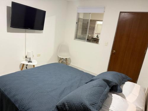 a bedroom with a bed and a flat screen tv at New Central Apartment 101 in Ocaña
