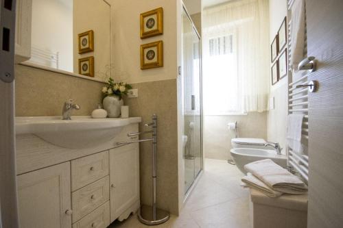 un bagno bianco con lavandino e WC di In Mons Iunonis ad Arezzo