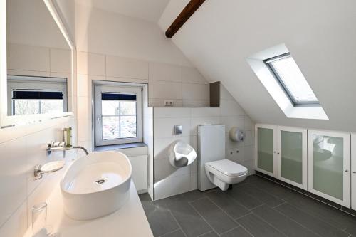 ein weißes Badezimmer mit Waschbecken und Toilette in der Unterkunft Brackweder Hof in Bielefeld