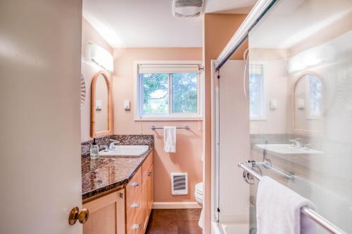 a bathroom with two sinks and a mirror at Twin Rocks Retreat in Rockaway Beach