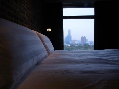 a bedroom with a large bed with a window at City Suites - Kaohsiung Pier2 in Kaohsiung