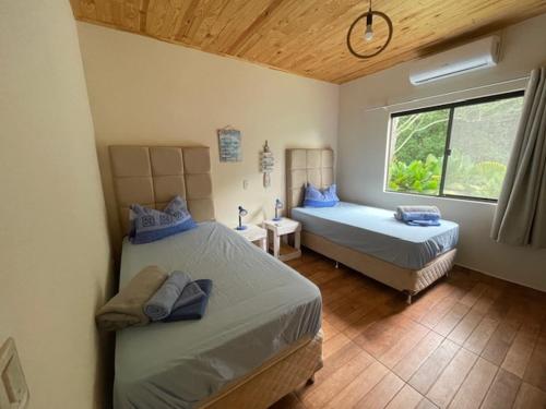 a bedroom with two beds and a window at Casa Bella Vista 1 Paraguay in Bella Vista