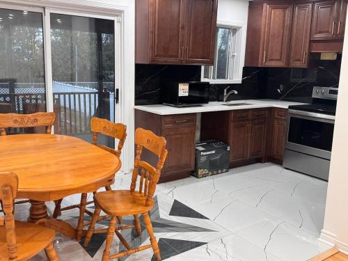 Charming Family Home in Peaceful Laval في لافال: مطبخ مع طاولة وكراسي خشبية